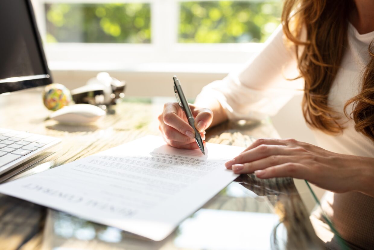 Businesswoman’s Hand Signing Contract With Pen